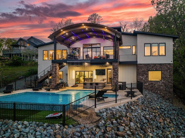 back of house with a patio, fence, a fenced in pool, a balcony, and stairs