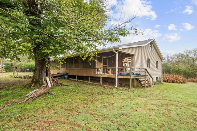 rear view of property featuring a yard, stairway, and a sunroom