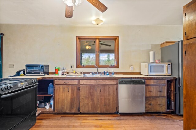 kitchen featuring light wood finished floors, ceiling fan, stainless steel appliances, light countertops, and a sink
