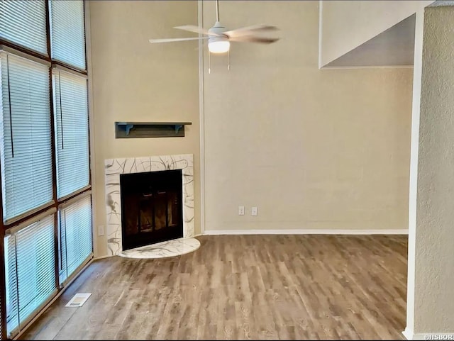 unfurnished living room with light wood-type flooring, a fireplace, visible vents, and baseboards