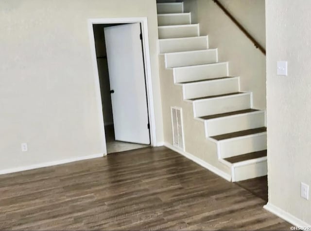 stairs with wood finished floors, visible vents, and baseboards