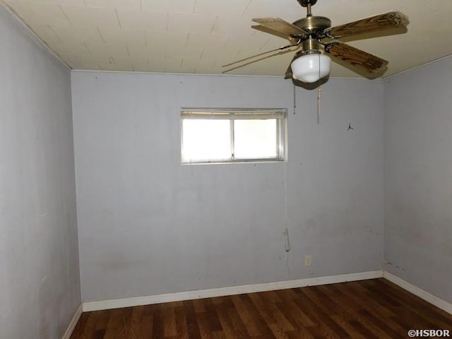 empty room featuring baseboards, wood finished floors, and a ceiling fan