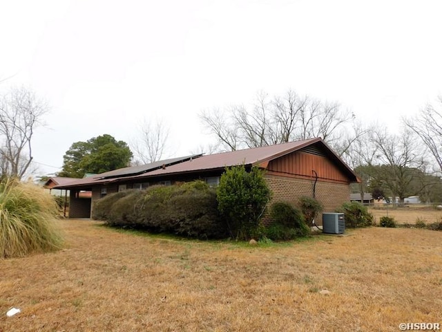 view of home's exterior with a yard, cooling unit, and brick siding