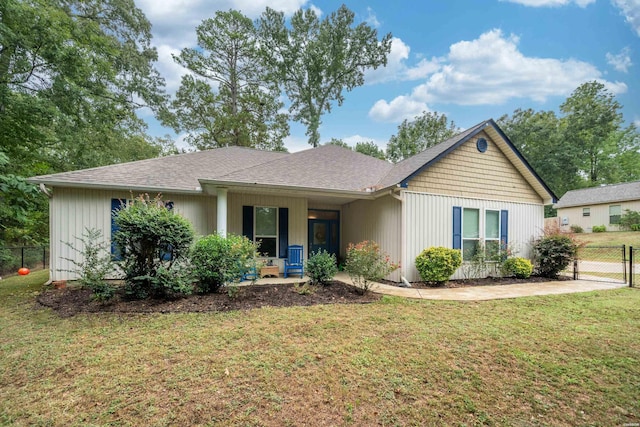 ranch-style home with covered porch, a front lawn, a shingled roof, and fence