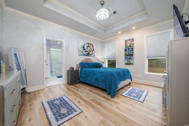 bedroom with light wood finished floors, a raised ceiling, and crown molding