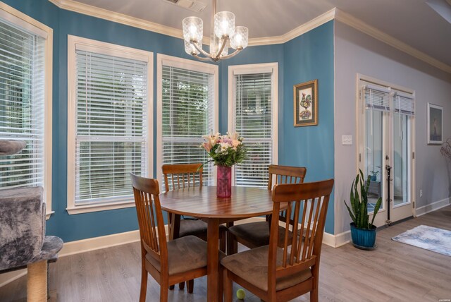 dining space featuring baseboards, a chandelier, crown molding, and wood finished floors