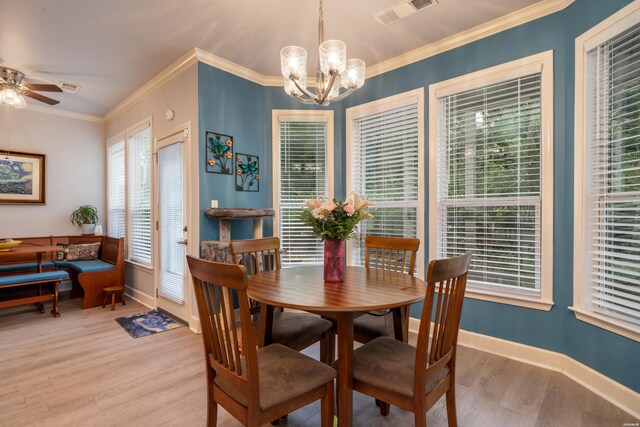 dining room featuring ceiling fan with notable chandelier, wood finished floors, visible vents, baseboards, and crown molding