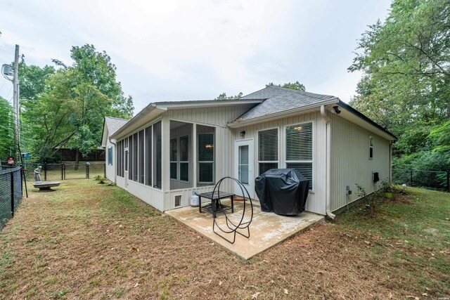 back of property with a lawn, a sunroom, a fenced backyard, a gate, and a patio area