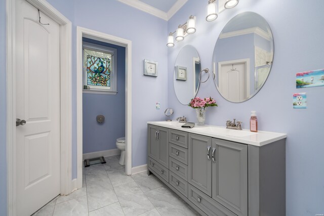 full bathroom with double vanity, a sink, toilet, and crown molding