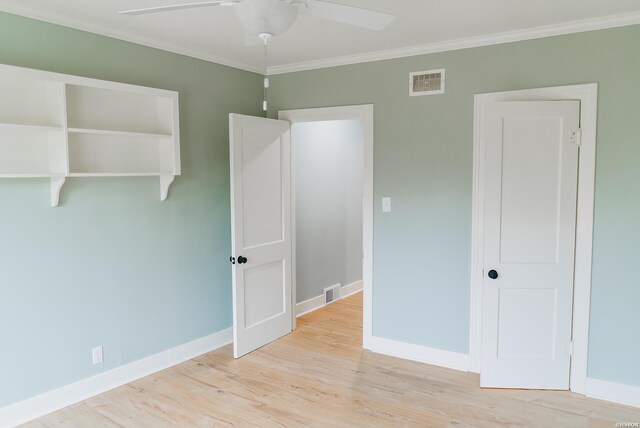 spare room featuring light wood finished floors, baseboards, visible vents, and a ceiling fan