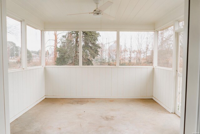 unfurnished sunroom featuring a ceiling fan