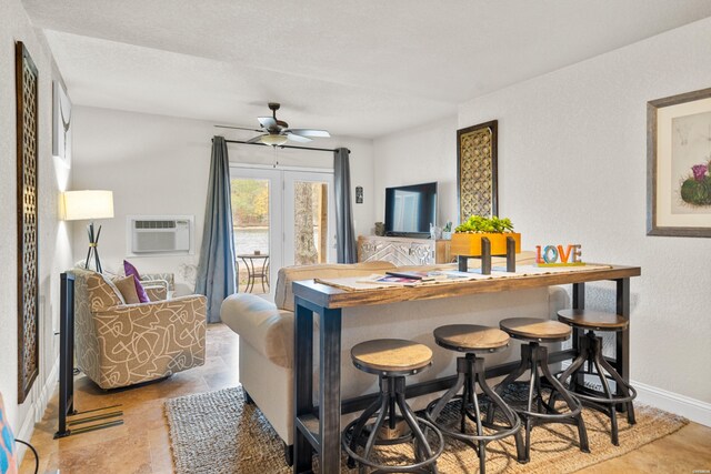 bar featuring a ceiling fan, a wall mounted air conditioner, and baseboards