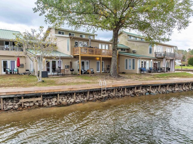 rear view of property with a water view, a balcony, and central AC unit