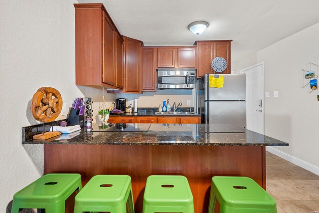 kitchen with stainless steel appliances, a sink, and a peninsula