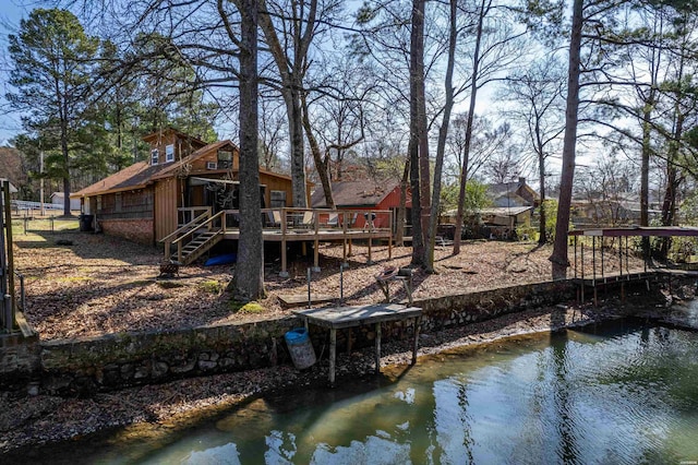 rear view of property featuring a deck with water view and stairway