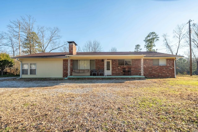 view of front of home featuring a chimney and brick siding