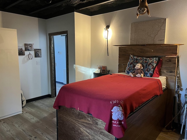 bedroom featuring wood finished floors and baseboards