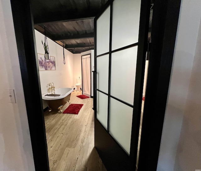 hall featuring beam ceiling, wooden ceiling, and light wood finished floors