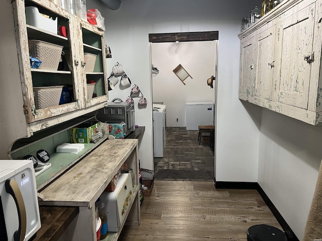 interior space with baseboards, washer and clothes dryer, and dark wood-type flooring