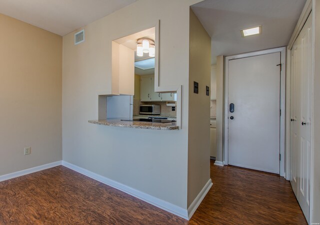 kitchen with visible vents, baseboards, tasteful backsplash, stainless steel microwave, and dark wood finished floors