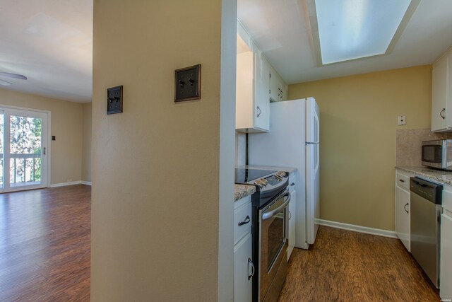 kitchen featuring baseboards, white cabinets, dark wood-style flooring, light stone countertops, and stainless steel appliances