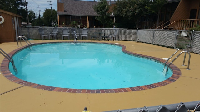 community pool with fence and a patio