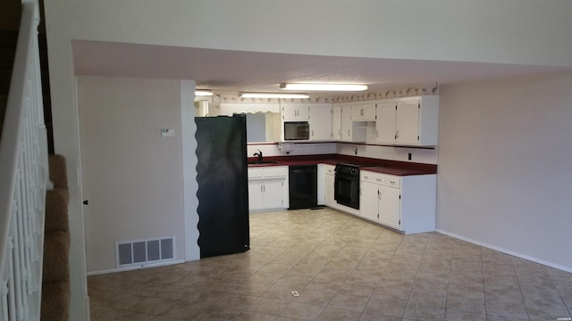 kitchen featuring dark countertops, visible vents, white cabinetry, a sink, and black appliances