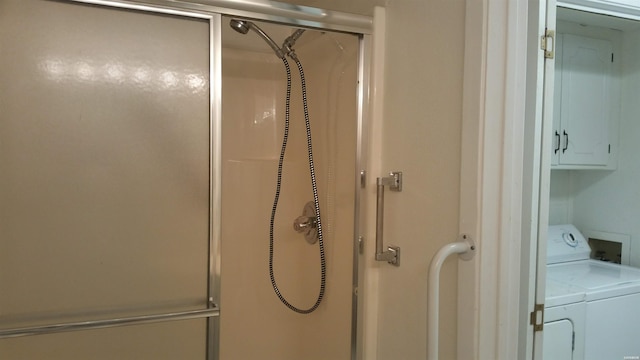 bathroom with a stall shower and washer and dryer