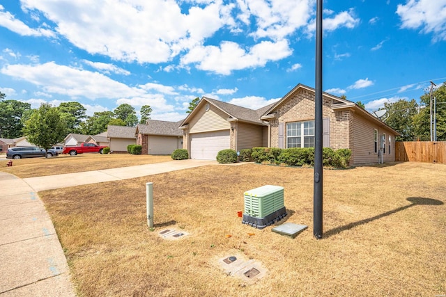 single story home featuring a garage, brick siding, concrete driveway, fence, and a front yard