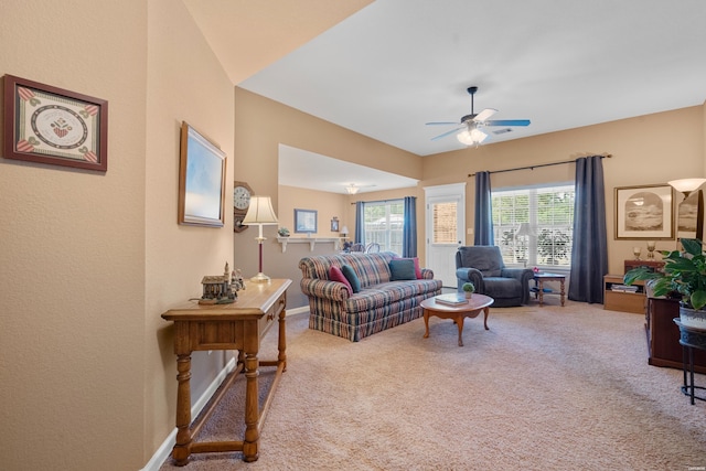 living room with baseboards, a ceiling fan, and carpet flooring