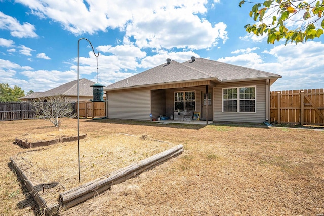 rear view of house with a shingled roof, a fenced backyard, a patio, and a lawn