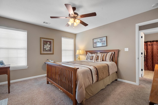 bedroom featuring a ceiling fan, light colored carpet, visible vents, and baseboards