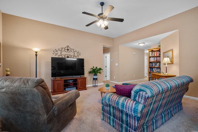 carpeted living area featuring a ceiling fan and baseboards