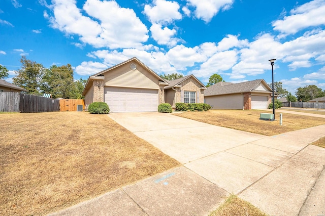 view of front of house with a garage, concrete driveway, fence, a front lawn, and brick siding