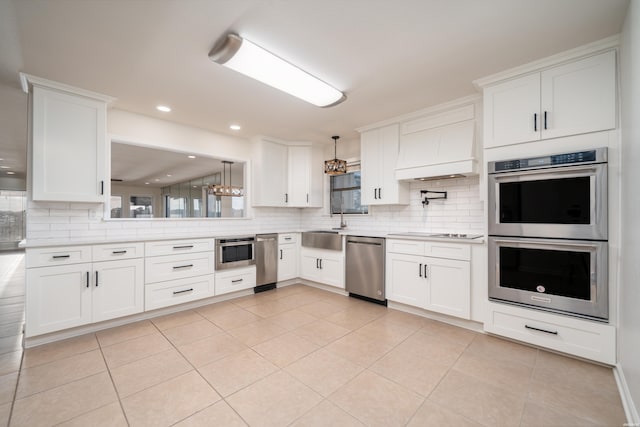 kitchen featuring light tile patterned flooring, white cabinets, light countertops, appliances with stainless steel finishes, and tasteful backsplash