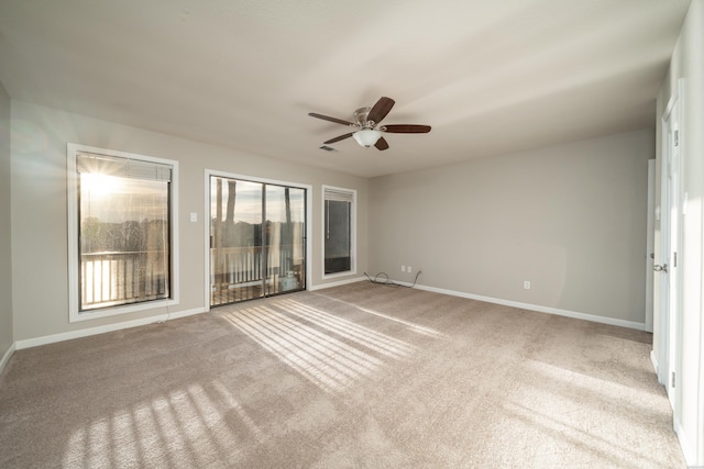 spare room featuring light carpet, ceiling fan, visible vents, and baseboards