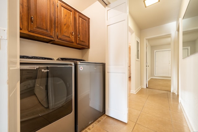 laundry room with cabinet space, light tile patterned floors, baseboards, and washer and dryer