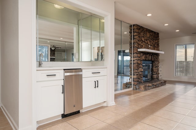 interior space featuring light tile patterned flooring, recessed lighting, a fireplace, a sink, and baseboards