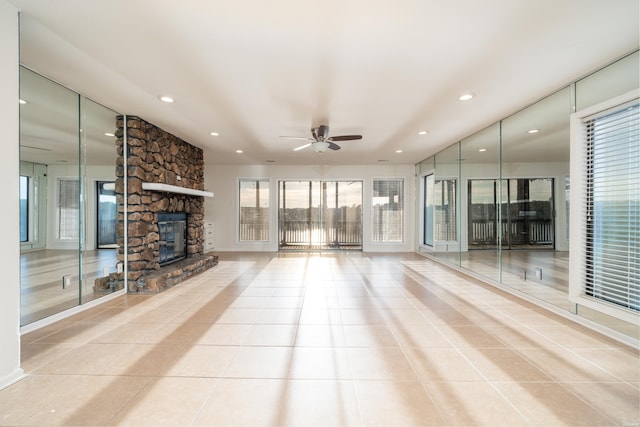 unfurnished living room with light tile patterned floors, a stone fireplace, a ceiling fan, and recessed lighting