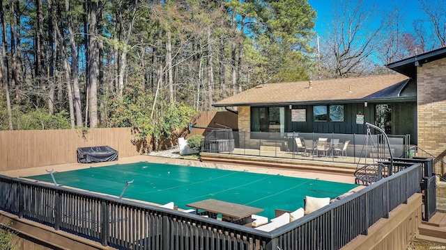 view of pool with a deck, outdoor dining area, and fence