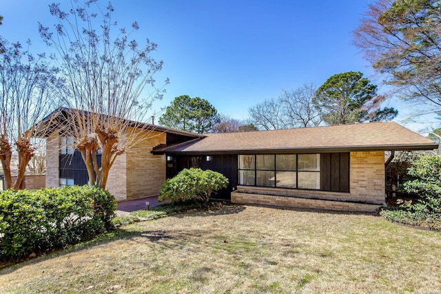 view of front of home featuring brick siding and a front lawn