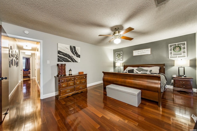 bedroom featuring a textured ceiling, visible vents, hardwood / wood-style flooring, and baseboards