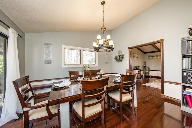 dining area featuring a chandelier, vaulted ceiling, and dark wood-style flooring