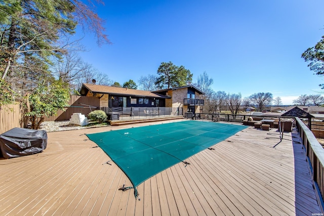 view of pool with fence, a fenced in pool, and a wooden deck