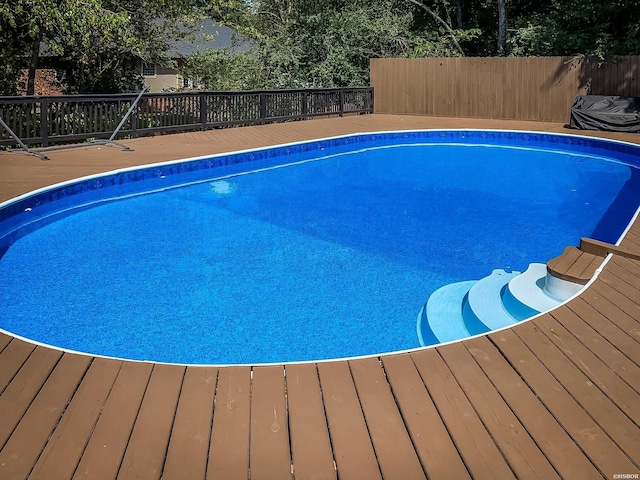 view of pool featuring a deck, fence, and a fenced in pool