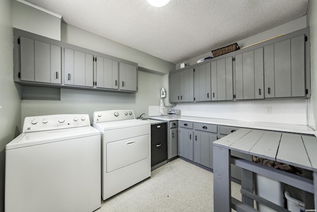 laundry room featuring cabinet space, washing machine and dryer, and a textured ceiling