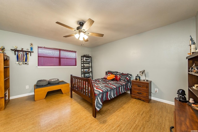 bedroom featuring a ceiling fan, baseboards, and wood finished floors