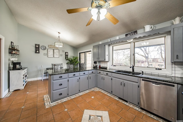 kitchen featuring light tile patterned floors, gray cabinets, a sink, dishwasher, and a peninsula