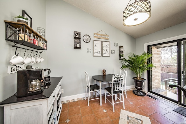 dining area with vaulted ceiling, baseboards, visible vents, and tile patterned floors