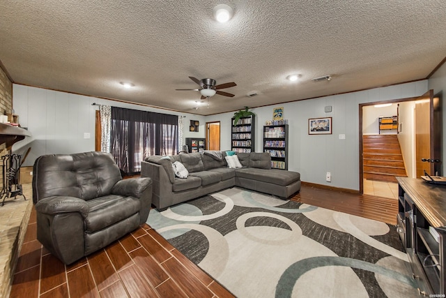 living room featuring crown molding, visible vents, stairway, wood tiled floor, and ceiling fan